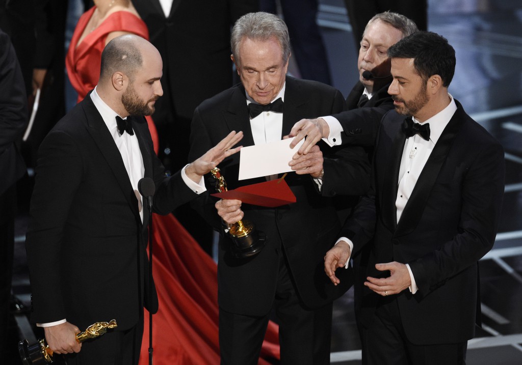 El productor de "La La Land" Jordan Horowitz, a la izquierda, el presentador Warren Beatty, en el centro, y el presentador Jimmy Kimmel, a la derecha, miran un sobre que anunciaba a "Moonlight" como ganadora del premio a mejor película, el domingo 26 de febrero de 2017, en el teatro Dolby de Los Ángeles. (Foto por Chris Pizzello/Invision/AP)